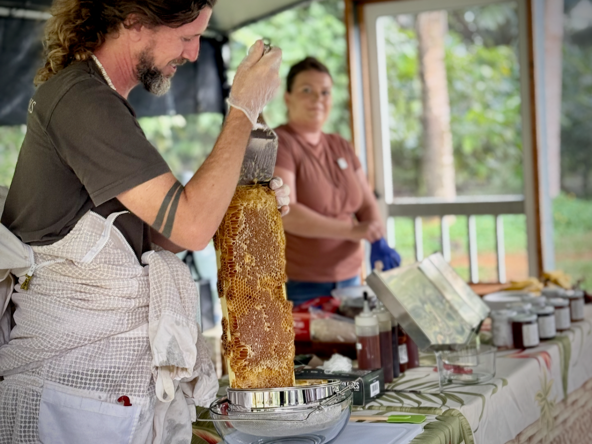 a person holding a piece of cake on a table